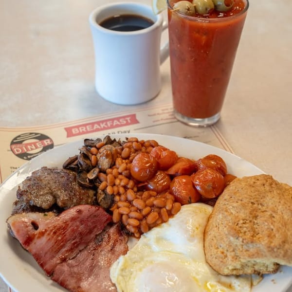 A full English breakfast with coffee and a Bloody Mary on a diner placemat.